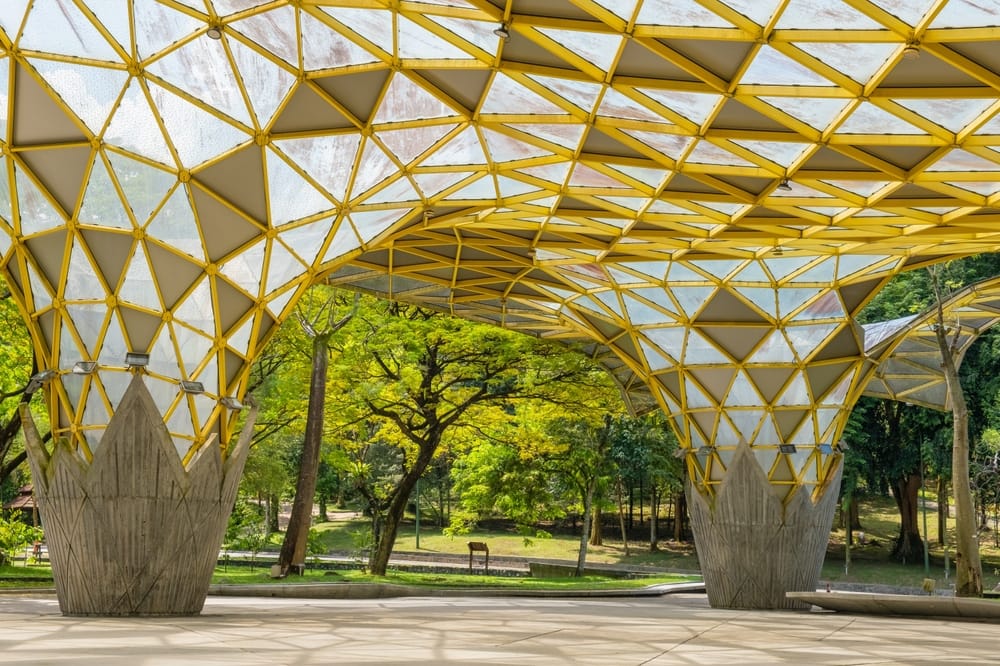 Moderne gul tagkonstruktion i Perdana Botanical Garden i Kuala Lumpur omgivet af grøn natur.