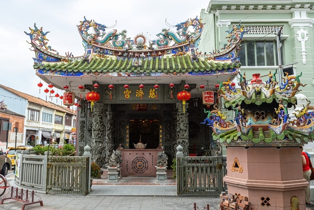 Farverigt kinesisk tempel med drageudsmykning og røde lanterner i George Town, Penang.