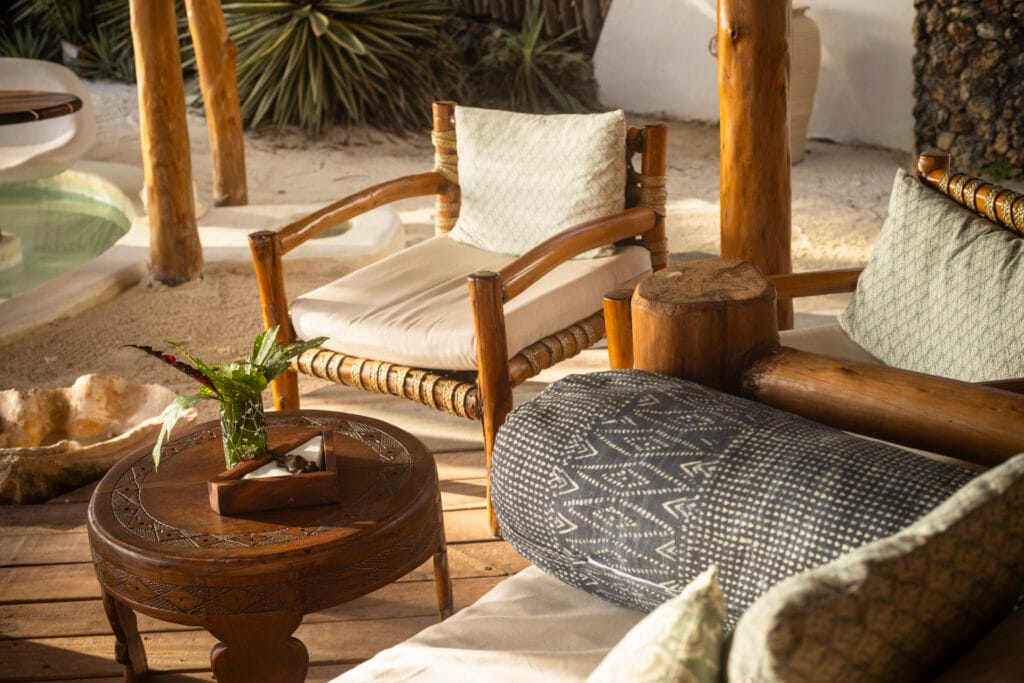 Loungeområde med håndlavede træmøbler og puder på Waterlover Beach Resort ved Diani Beach