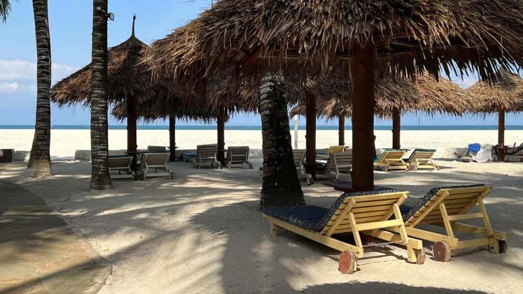 Solsenge og stråparasoller på stranden ved Pinewood Beach and Spa Resort