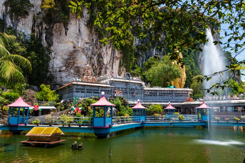 Batu Caves tempel omgivet af kalkstensklipper, sø og farverig gangbro i Selangor, Malaysia.