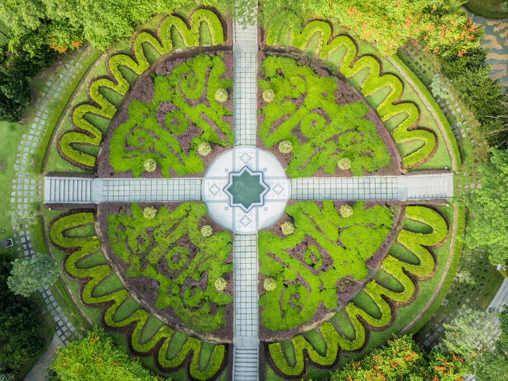 Luftfoto af symmetrisk anlagt have med cirkulært mønster og grønne bede i Perdana Botanical Garden i Kuala Lumpur.