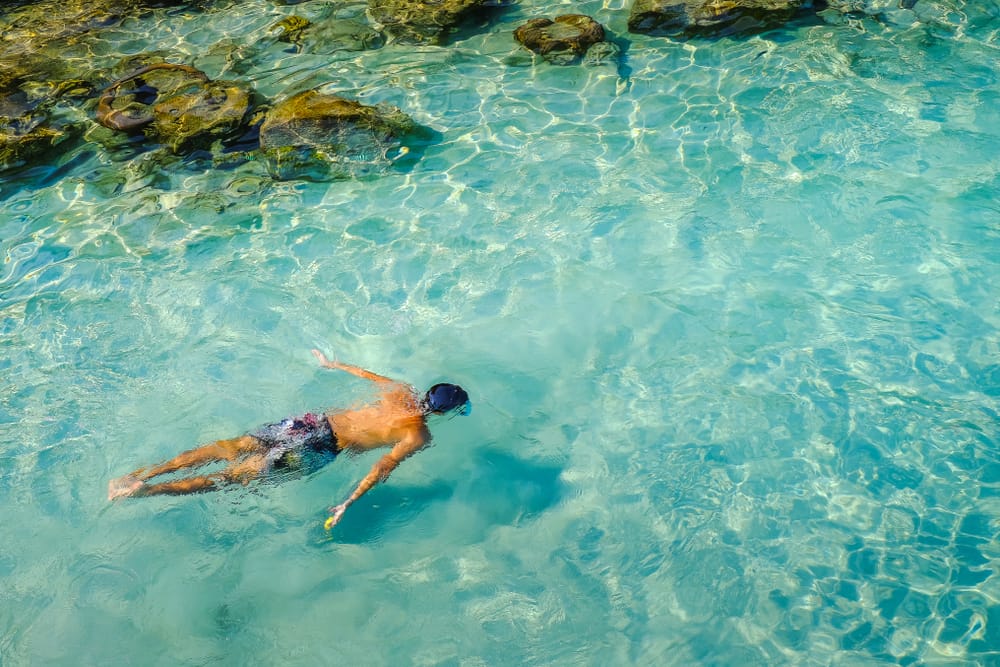Snorkler i krystalklart, lavt vand ved Perhentian Islands i Malaysia