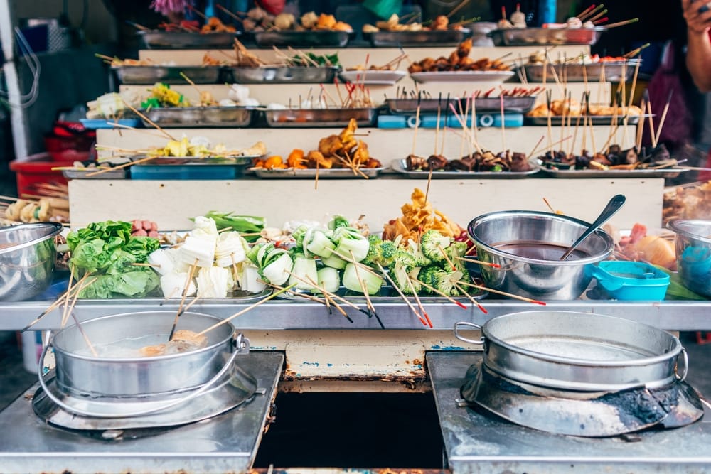 Malaysisk street food med spyd og grøntsager på madbod i Malacca.