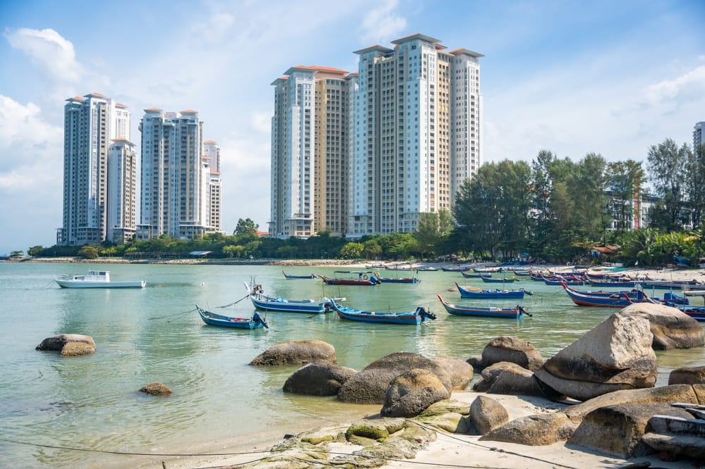 Fiskerbåde i havnen på Penang med moderne højhuse i baggrunden