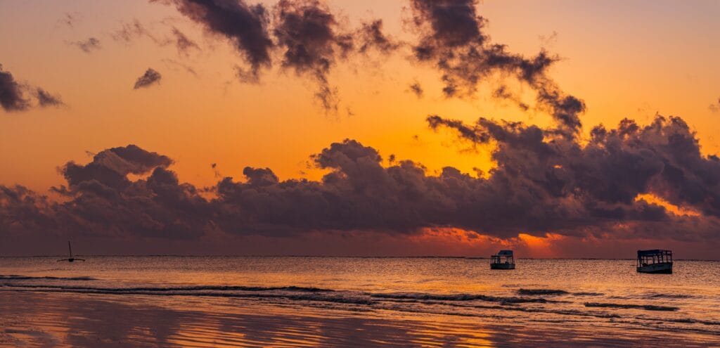 Solnedgang over Det Indiske Ocean med både ud for kysten ved Pinewood Beach and Spa Resort