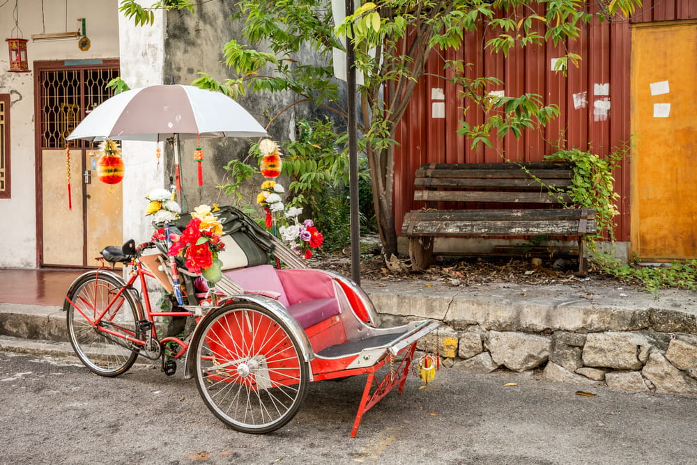 Farverig trishaw dekoreret med blomster og lanterner i George Town på Penang