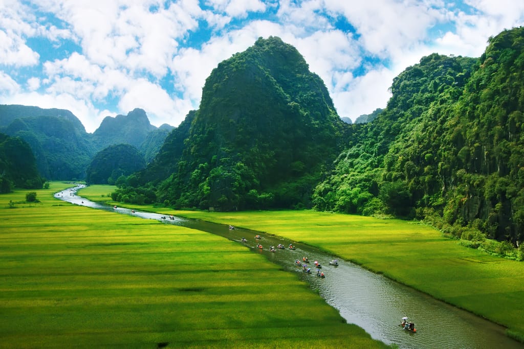 Rismarker og flod i Ninh Binh, Vietnam – frodigt landskab med grønne marker, traditionelle landsbyer og idyllisk flodmiljø. » Tembo Travel Rismarker og flod i Ninh Binh, Vietnam – frodigt landskab med grønne marker, traditionelle landsbyer og idyllisk flodmiljø.