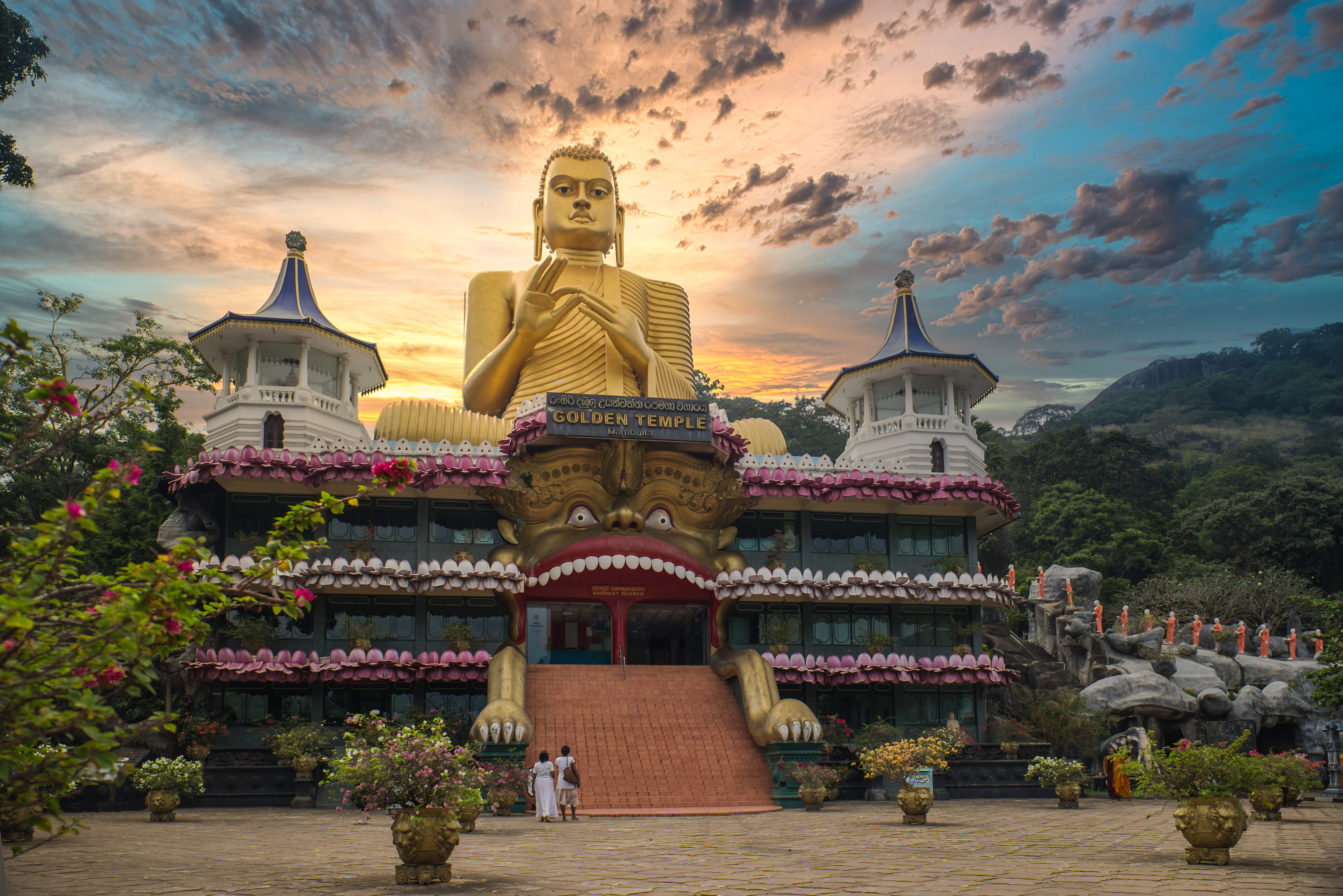 En enorm gylden Buddha-statue på toppen af et museum i Thailand. Den majestætiske figur stråler i solen og symboliserer fred, styrke og spirituel visdom – et imponerende vartegn og populært rejsemål for kultur- og religionsinteresserede besøgende.