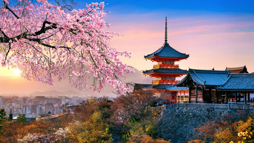 En rød pagode rejser sig blandt kirsebærblomster, badet i det gyldne lys fra solnedgangen i Japan.