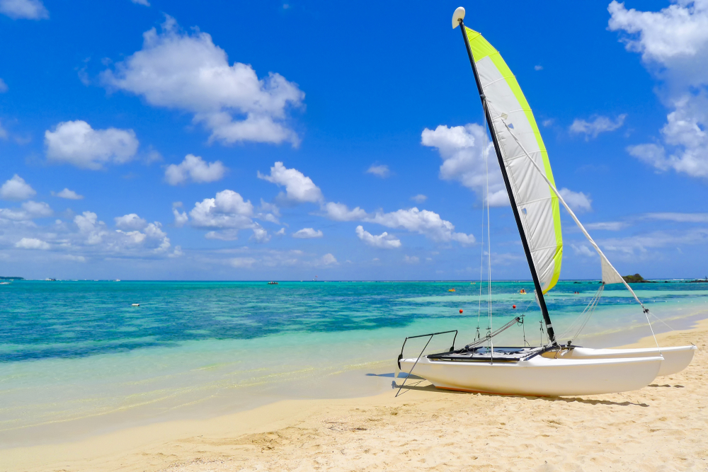 Katamaran ved Mont Choisy Beach på Mauritius med turkisblåt hav i baggrunden.