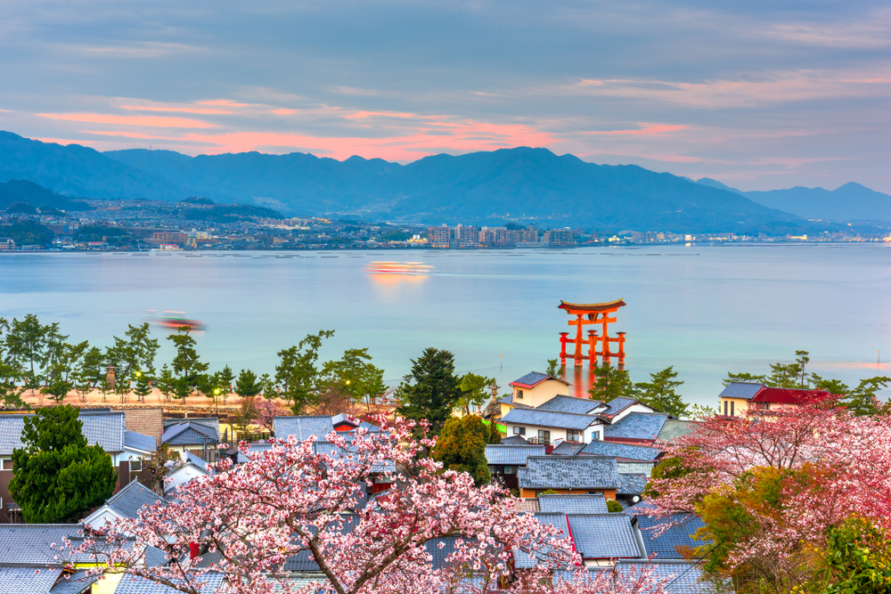 Miyajima Island i Hiroshima, Japan, med traditionelle templer langs bredden af Seto Indlandshavet omgivet af naturskønne omgivelser