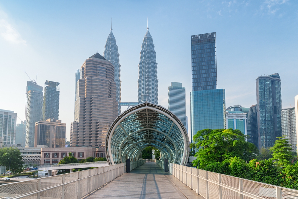 Udsigt over Kuala Lumpurs moderne skyline med imponerende skyskrabere mod en klar blå himmel